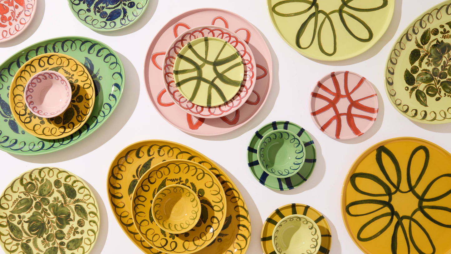 Collection of colorful ceramic plates with floral patterns on a white background
