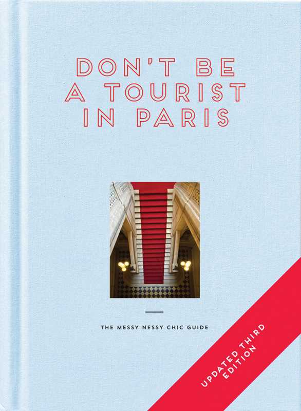 Book cover of 'Don't Be a Tourist in Paris' with a red and white design on a light blue background.