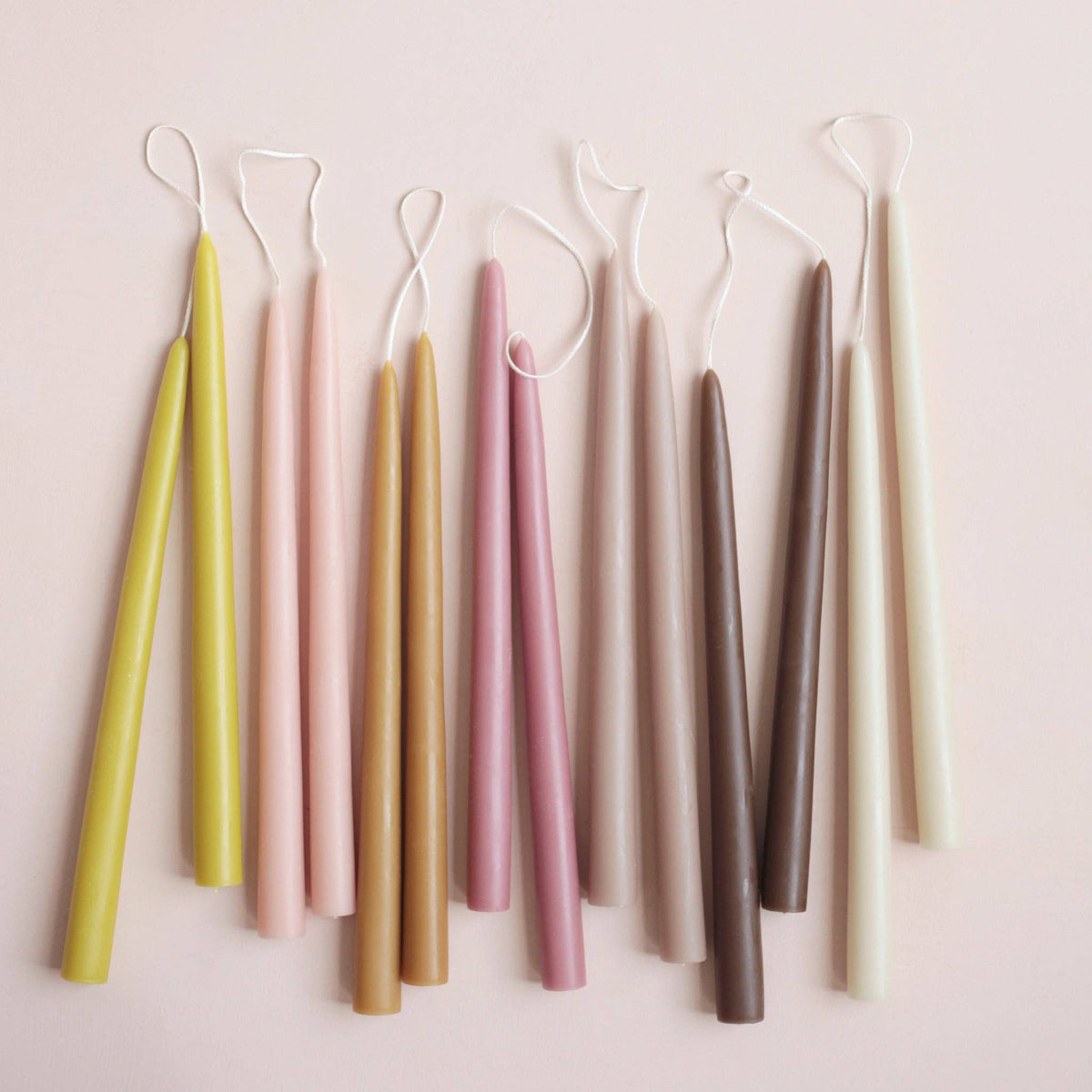 Set of colorful candles on a light pink background