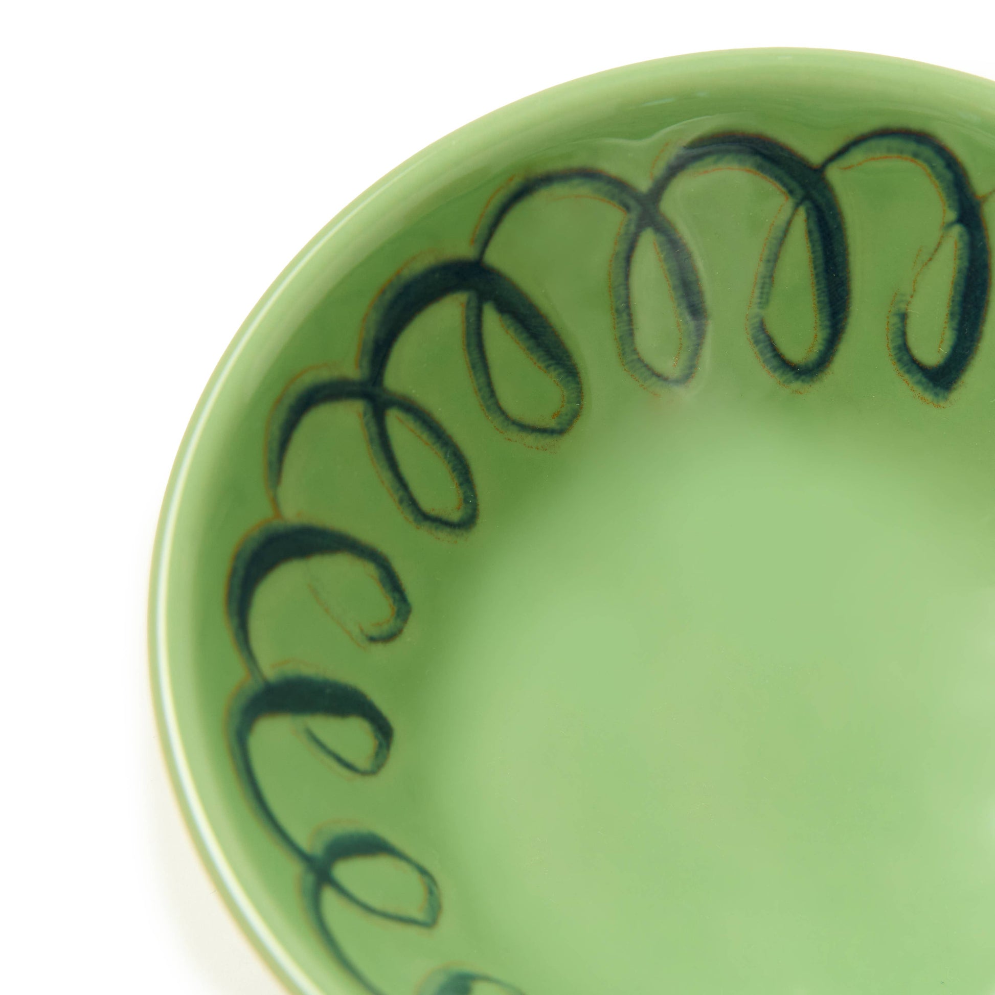 Green ceramic bowl with black decorative patterns on a white background