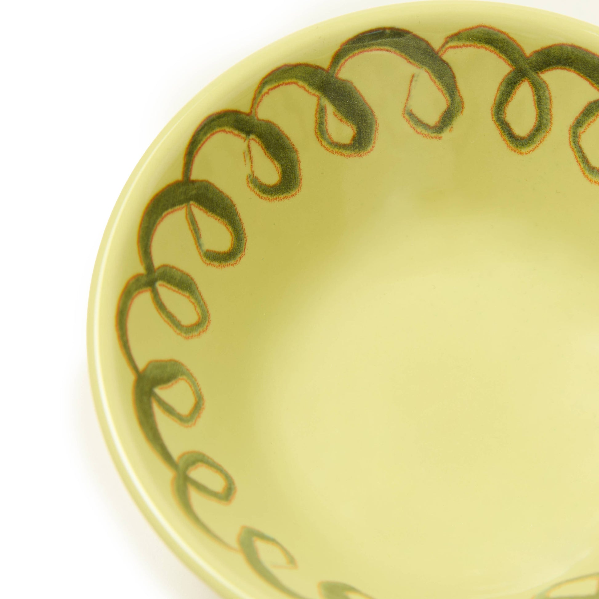 Yellow ceramic plate with green decorative edge on a white background