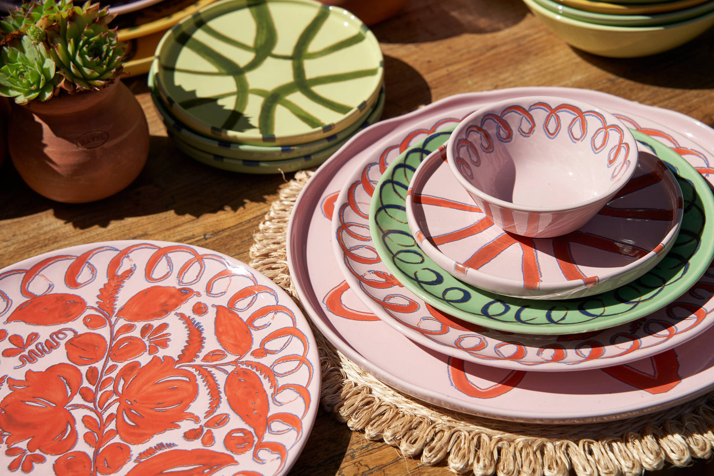 Colorful ceramic plates with floral patterns on a wooden table.