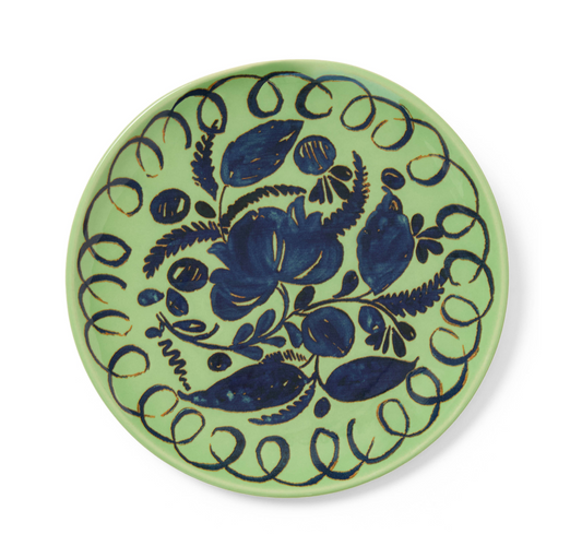 Ceramic plate with blue floral design on a green background