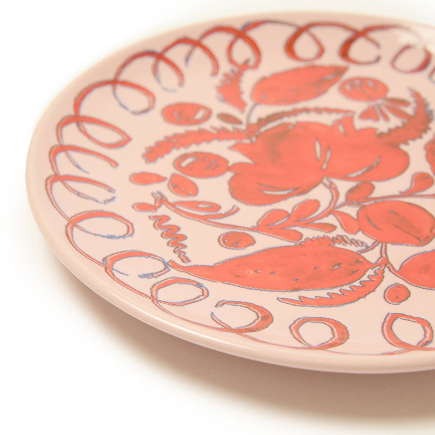 Ceramic plate with red crab design on a beige background